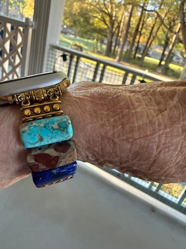 Reviewer's wrist wearing the Chic Chakra Stretch Apple Watch Strap, showing its colorful stone beads.