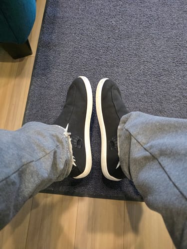 Customer's point-of-view looking down at their feet in the black Oso CG2 barefoot shoes indoors.