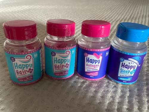 Cliente exibe os quatro potes do kit recebido: dois potes de Happy Hair, um de Happy Collagen e um de Happy Sleep.