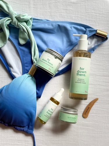 Customer's Superfood Intimate Care Kit products displayed next to a blue bikini on a white cloth.