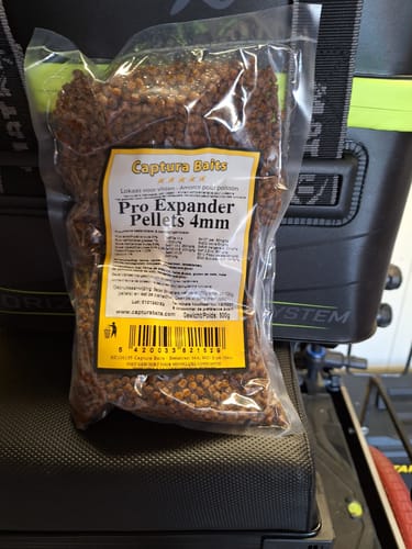 Klant toont een doorzichtige zak met 4mm Pro Expander Pellets van Captura Baits.