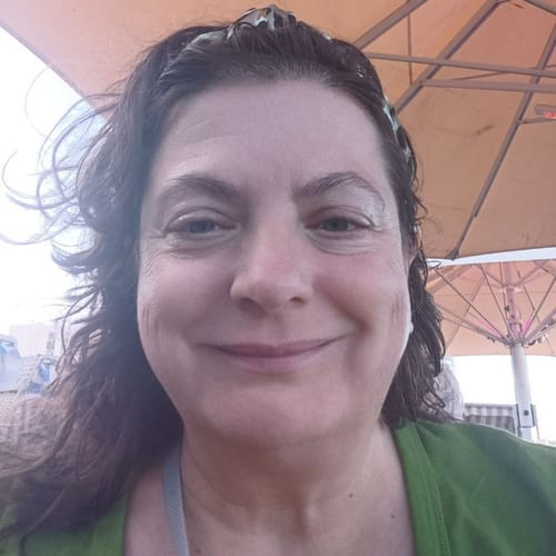 Kundin lächelt und zeigt ihre langen, gewellten Haare nach der Verwendung der Apple-Wonder Haarseife.