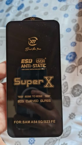 Customer holds the UltraShield Tempered Glass on its black backing card with gold feature text.
