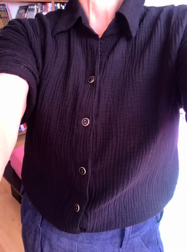 Cliente portant la Chemise Honorine noire, montrant la texture gaufrée de la double gaze de coton.