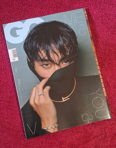 Reviewer's copy of the GQ Magazine with BTS V on the cover, laid on a textured red background.