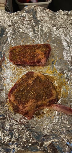 Customer's raw, seasoned Bone-in and Boneless Ribeyes from The Carnivore Collection on aluminum foil before cooking.