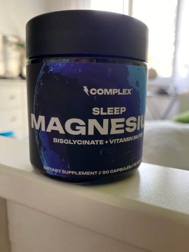 Customer's black bottle of Complex Sleep Magnesium capsules sitting on a white shelf.