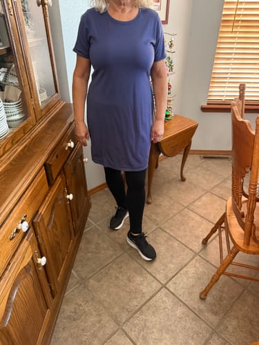 Reviewer showing the casual fit of the Lexie Dress in ink blue, worn over leggings in a home setting.