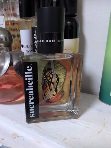 Customer's bottle of Chrysalis perfume, showing the square glass bottle and label art of a chrysalis on a shelf.