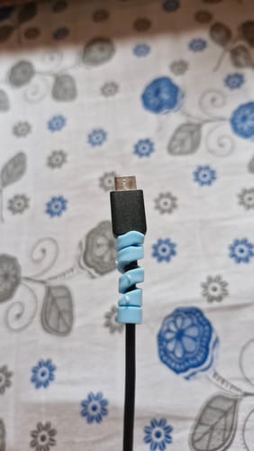 Close-up of a reviewer's light blue cable protector wrapped around a black cable.