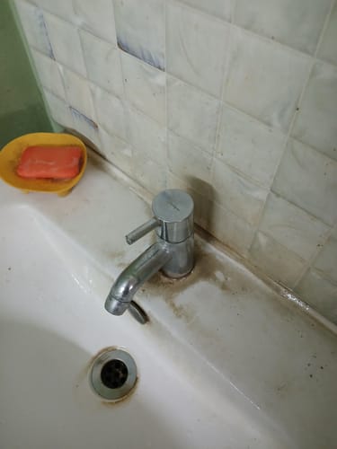 Customer's sink showing tough limescale stains around the faucet and drain before using the Limescale Remover.