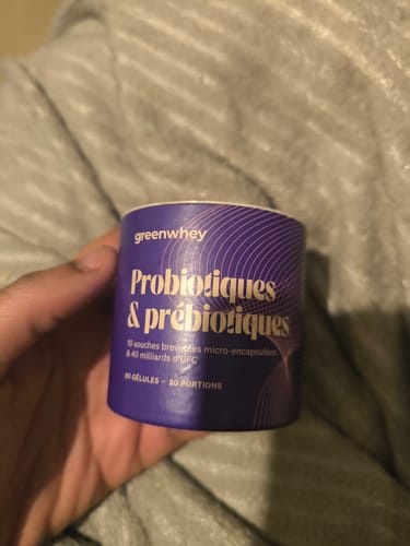 Une cliente tient le pot violet de Probiotiques & Prébiotiques dans sa main.