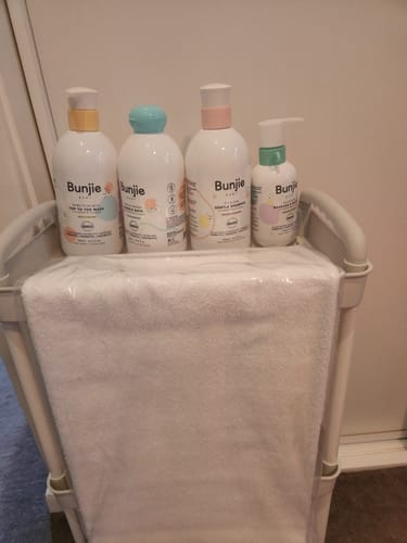 Customer's Bunjie baby products from the All-Star Shelfie bundle on a white changing cart.
