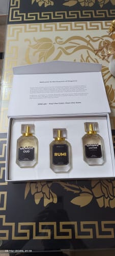 Customer's open Winter Box, showing the Black Oud, Rumi, and Ombre Leather perfume bottles inside on a decorative table.
