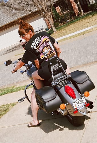 Reviewer on a motorcycle wearing the black Spark and Spiral T-Shirt, showing the large, colorful graphic on the back.