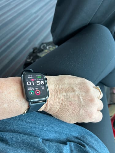 Customer wearing a black smartwatch with a rectangular face showing health metrics.