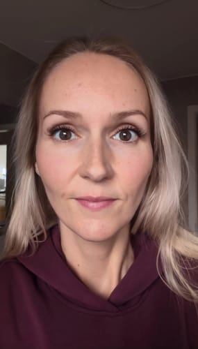 Eine Kundin zeigt ihre Augen, nachdem sie die Wimpern der Cat Eye Edition Mini Boxen für einen Cat-Eye-Look angelegt hat.