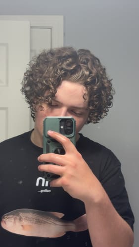 Reviewer showing their defined, curly hair after using the Shower Duo.