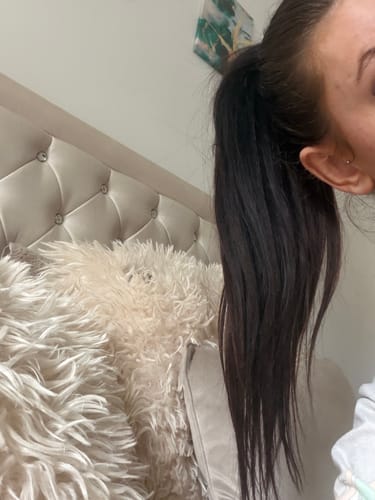 Close-up of a customer showing the thick, dark Stranded Blowout Clip-in Ponytail from the side.