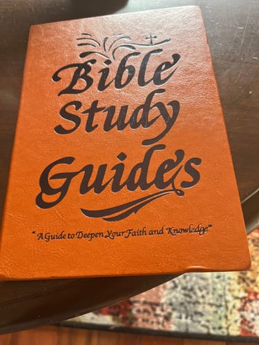 Customer's Bible Study Guide journal with a textured orange cover laid on a wooden surface.