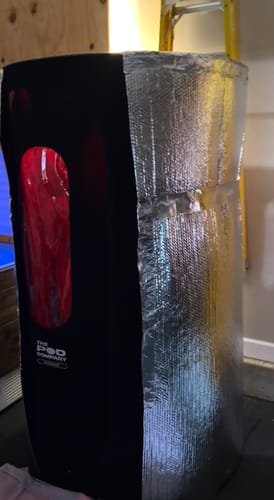 Customer's black Sauna Pod, partially wrapped in silver insulation foil.