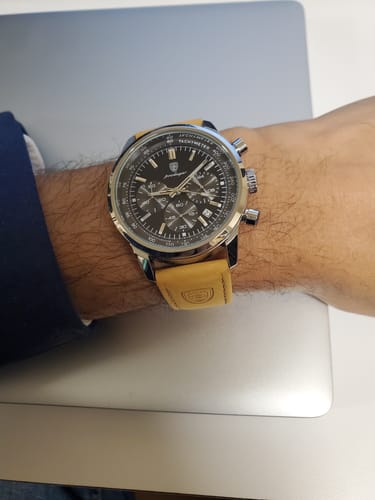 Customer wearing the Lucky Fours® Meridian watch, featuring a black chronograph dial and a tan leather strap.