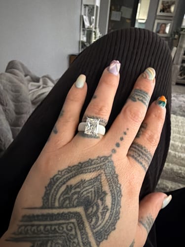 Customer's tattooed hand wearing the white Silicone Ring with a large emerald-cut CZ.