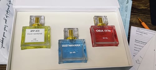 Customer's OUD Supreme BUNDLE showing three colorful perfume bottles, Oud Serene, Oud Nirvana, and Ora 1776, in a white box.