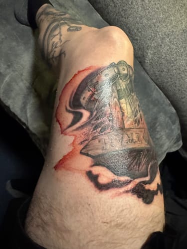 Customer's leg with a fresh, red tattoo around the knee immediately after their session.