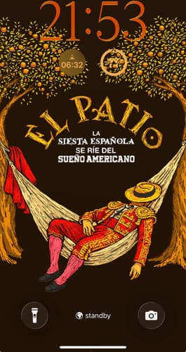 Reviewer's phone lock screen with the El Patio Naranjas Wallpaper, showing a matador napping in a hammock.