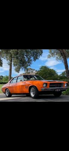 Reviewer's shiny orange classic car parked on a driveway after using the waterless wash.