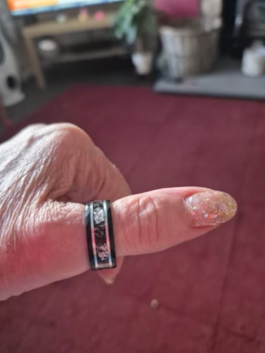 Reviewer's thumb shown in a close-up, wearing the black Titanfall ring with its meteorite and gold inlay.