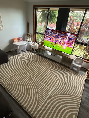Reviewer's Sahara Lines Mellow Mat in a bright living room, styled in front of a TV and near kids' furniture.