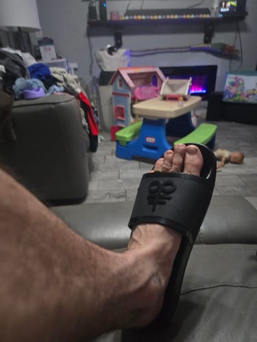 Customer wearing a black Leviathan Slide indoors, showing the comfortable fit on their foot.