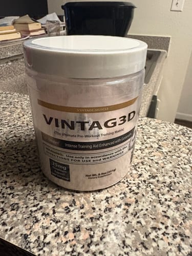 Customer's tub of VINTAG3D pre-workout powder resting on a granite countertop.
