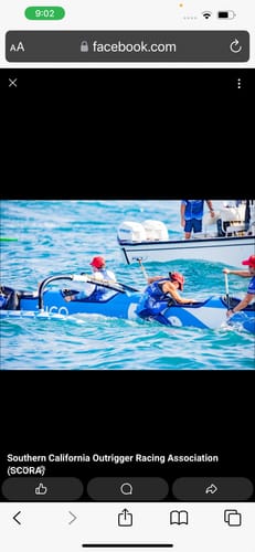 Reviewer paddling in a blue outrigger canoe during a race, an activity mentioned in their review.