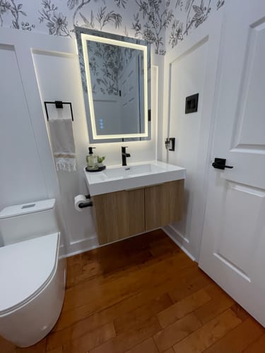 Reviewer's fluted Bellezza Floating Vanity in an Oak finish installed in a modern powder room.