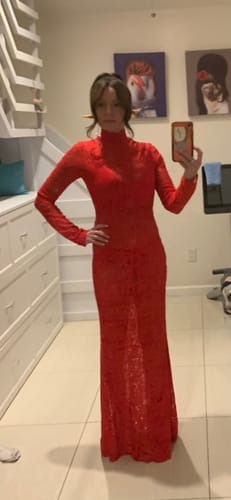 Reviewer standing in the red high neck sheer lace bodycon maxi dress.