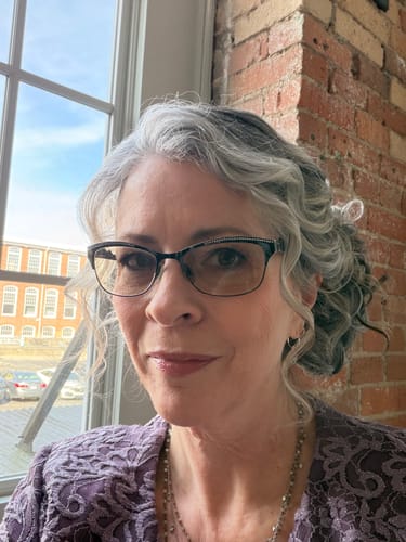 Reviewer wearing the salt and pepper JuvaBun Messy bun in a stylish side updo.