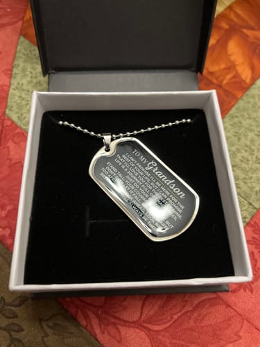 Customer's 'To My Grandson' Love Tag necklace resting in its black gift box, showing the engraved message.