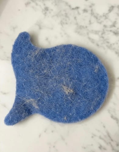 Customer's blue Laundry Pet Hair Removal Fish covered in light-colored pet hair after use.