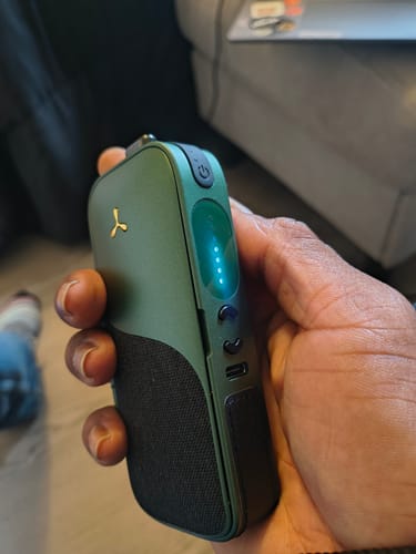 Customer holding the sleek, green Legacy CORE. Its side display is on and glowing brightly.