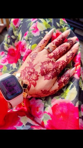 Close-up of a customer's hand with henna, wearing a ring and gold-colored bracelet from their 5-piece purchase.