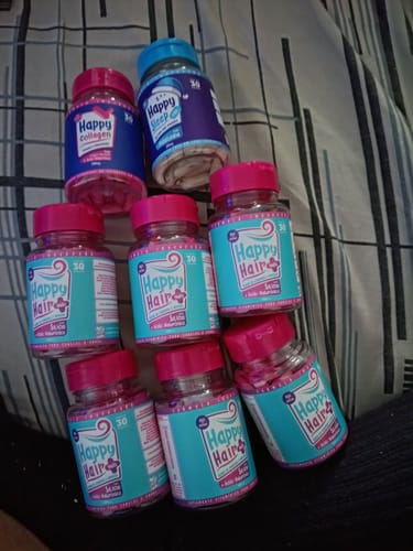 Cliente exibe os 8 potes do seu kit: seis potes de Happy Hair, um de Happy Collagen e um de Happy Sleep.