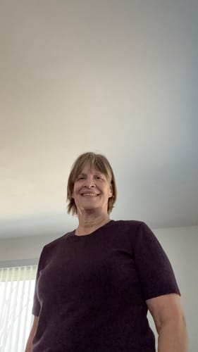 Reviewer wearing the short-sleeve Anna Crew Sweater in a deep plum color.