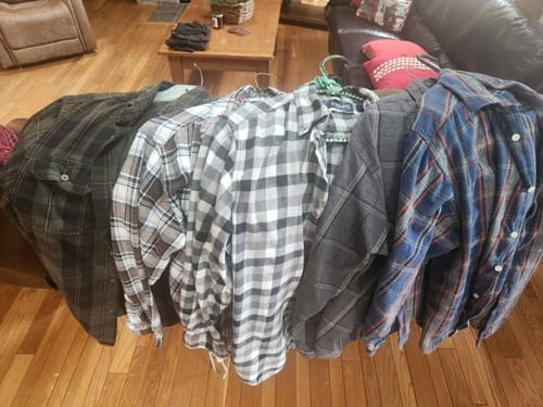 Customer showing the assortment of clean flannel shirts from their wholesale order after washing.