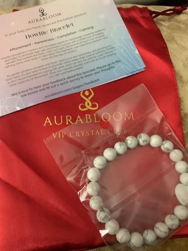 Reviewer's VIP Crystal Club delivery with a white Howlite bracelet shown in its packaging next to a red pouch.