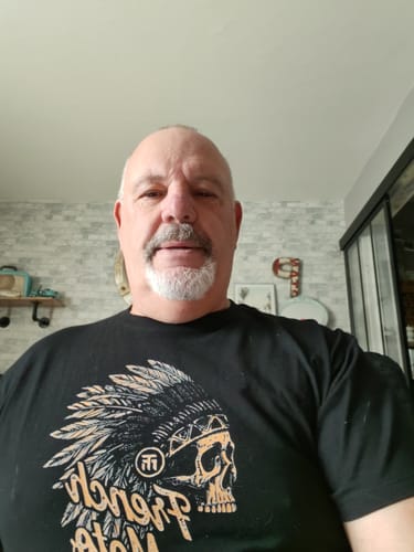 Client portant le T-shirt noir de la COLLECTION UPSIDE DOWN avec un motif de crâne à coiffe indienne.
