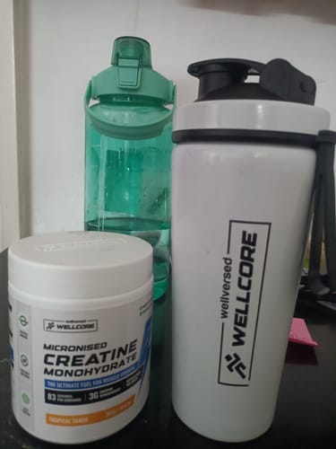 Customer's Wellcore Creatine Monohydrate tub and white Premium Steel Shaker on a countertop.
