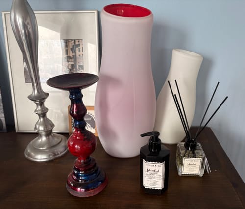 Recensent toont de Istanbul geurstokjes en een bijpassende handzeep op een houten dressoir.